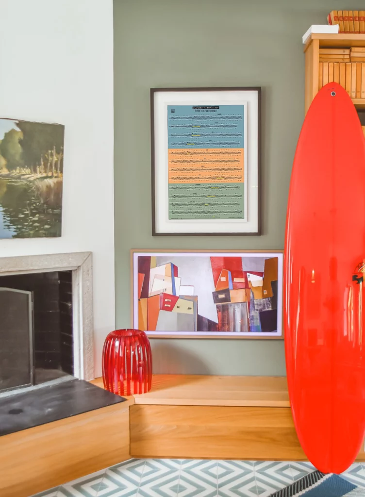 Photo d'une affiche les marées rayée dans un salon avec une board rouge